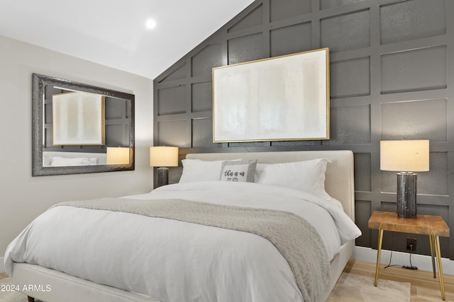 bedroom featuring light hardwood / wood-style flooring and lofted ceiling