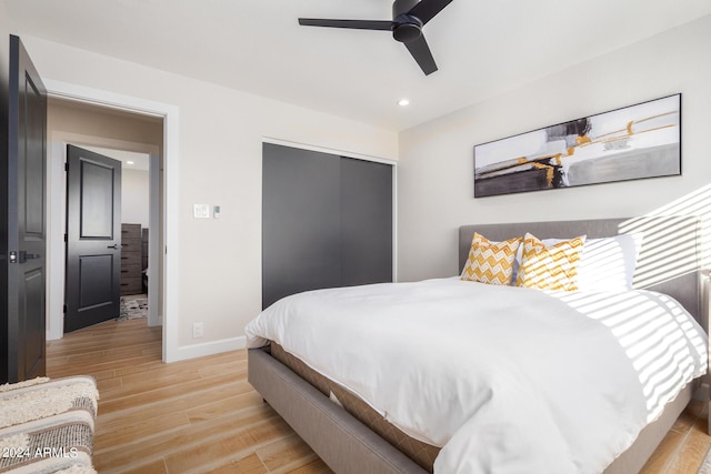 bedroom featuring light hardwood / wood-style floors, a closet, and ceiling fan