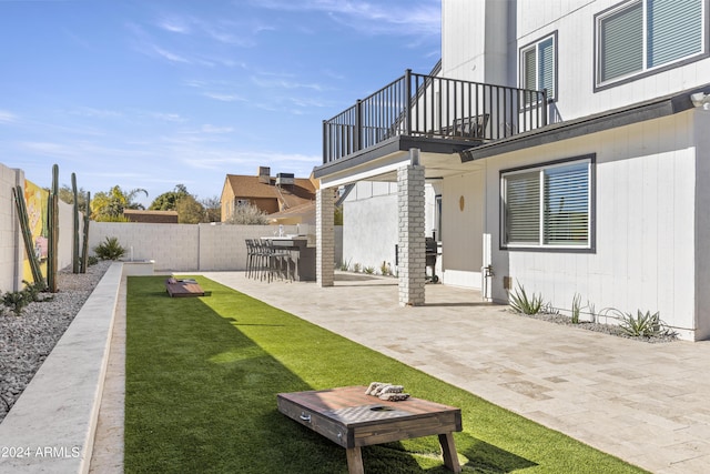 view of yard with a patio area, a balcony, and exterior bar