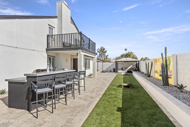 exterior space featuring exterior bar, a patio, and a balcony