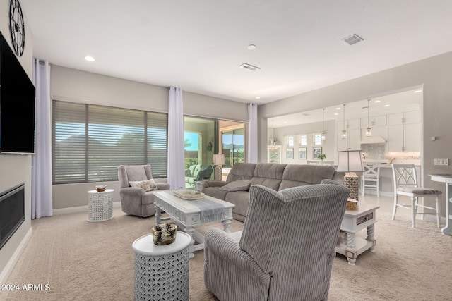 living room featuring a fireplace and light colored carpet