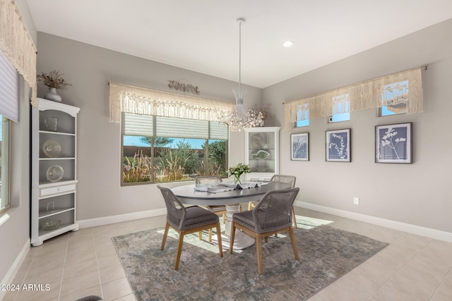 tiled dining area featuring a chandelier