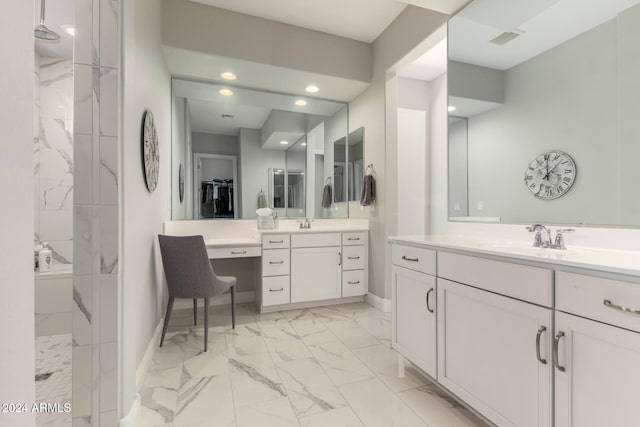 bathroom featuring tiled shower and vanity