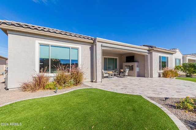 rear view of house featuring a patio area and a yard