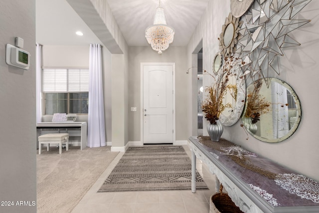 entrance foyer featuring light colored carpet and an inviting chandelier