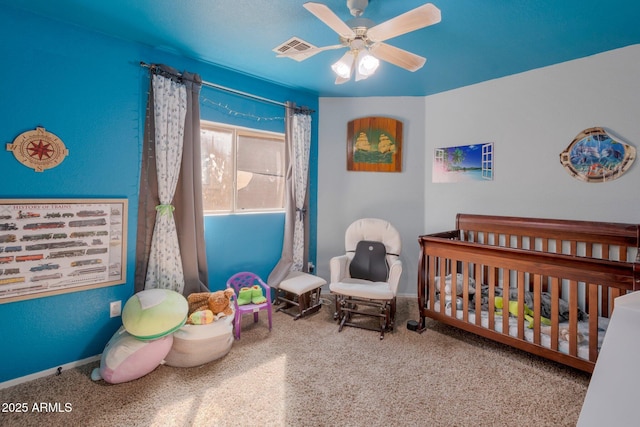 bedroom featuring a nursery area, ceiling fan, and visible vents