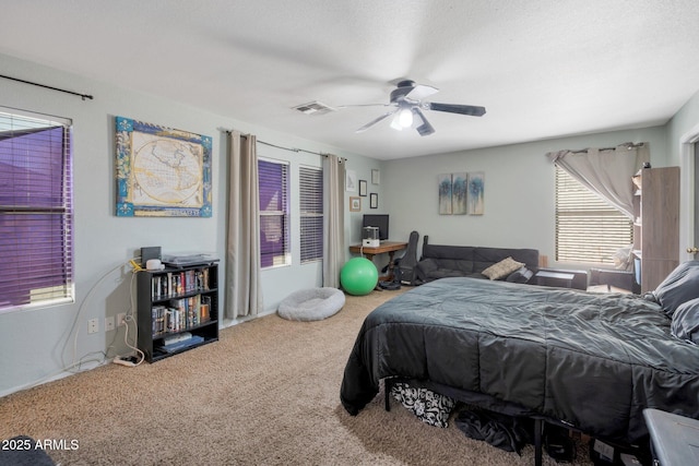 carpeted bedroom with ceiling fan, a textured ceiling, and visible vents