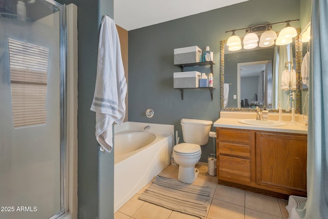 bathroom featuring a stall shower, toilet, tile patterned floors, a garden tub, and vanity