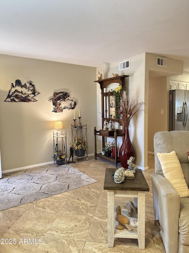 interior space featuring baseboards, visible vents, and a textured ceiling