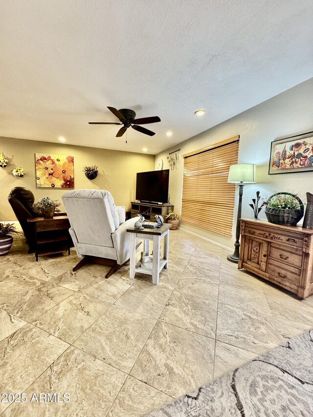 living area featuring a textured ceiling, ceiling fan, and recessed lighting