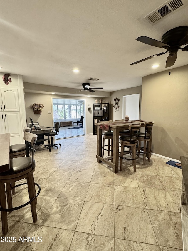 dining space featuring a ceiling fan, visible vents, and baseboards
