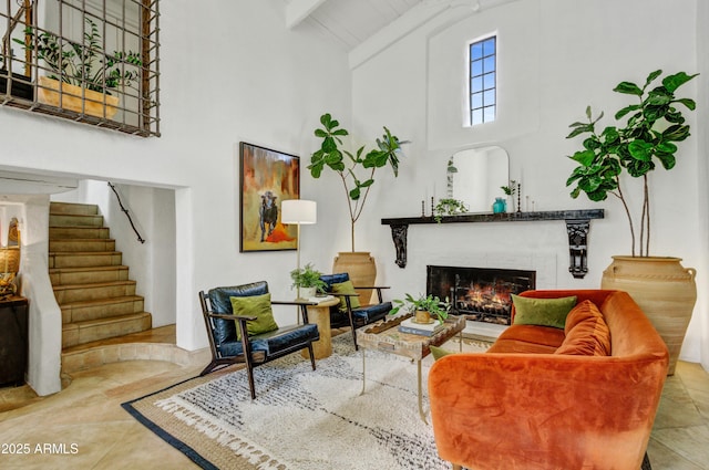 living room featuring beamed ceiling, a fireplace, and high vaulted ceiling