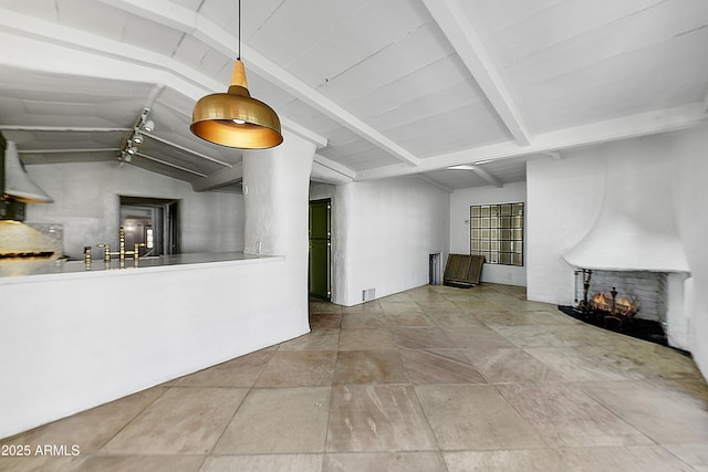 unfurnished living room with a multi sided fireplace and lofted ceiling with beams