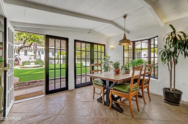 dining space featuring vaulted ceiling with beams