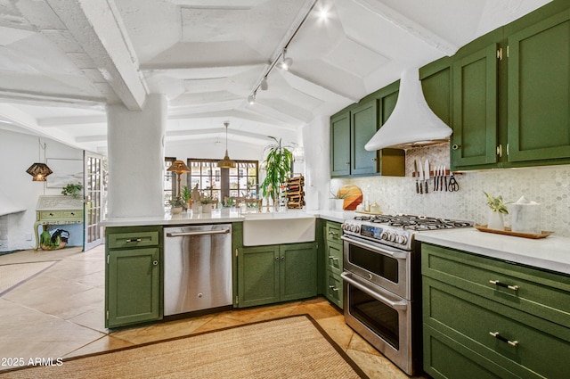 kitchen featuring appliances with stainless steel finishes, lofted ceiling with beams, custom range hood, green cabinetry, and decorative backsplash