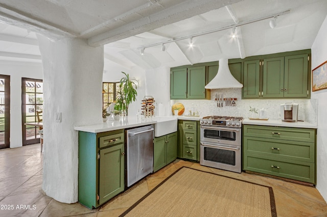 kitchen featuring premium range hood, appliances with stainless steel finishes, and green cabinets