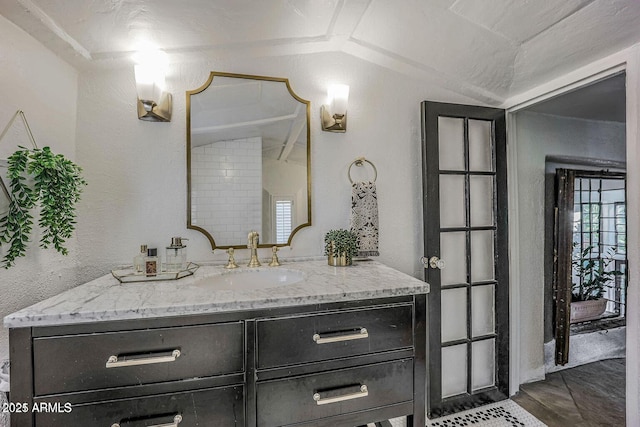 bathroom featuring vanity and lofted ceiling