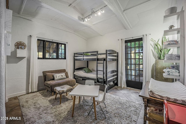 bedroom with track lighting, tile patterned floors, and vaulted ceiling with beams