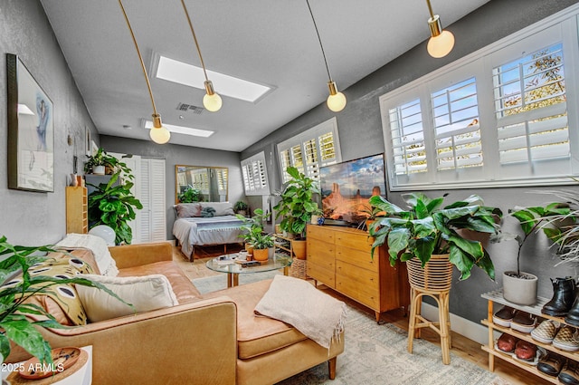 interior space featuring multiple windows, wood-type flooring, ceiling fan, and a skylight