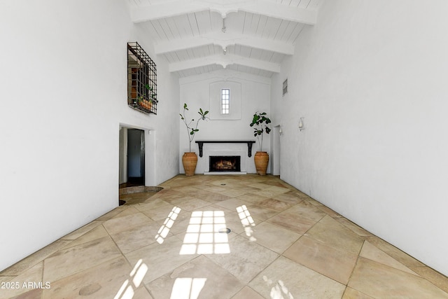 unfurnished living room with beamed ceiling, high vaulted ceiling, and wood ceiling