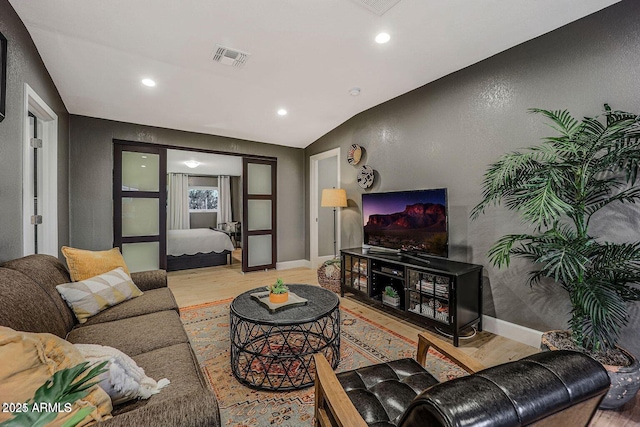 living room featuring vaulted ceiling and light wood-type flooring