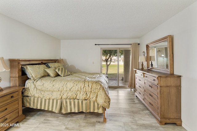 bedroom with access to exterior and a textured ceiling