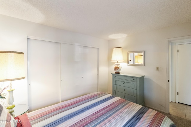 bedroom with a textured ceiling and a closet