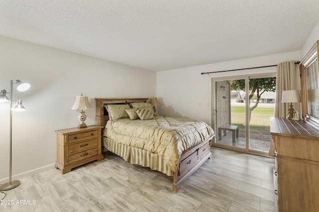 bedroom featuring access to exterior and a textured ceiling