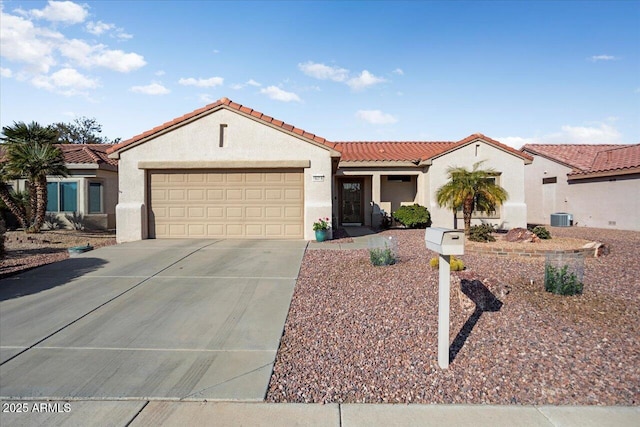 mediterranean / spanish-style home with a garage and central AC unit