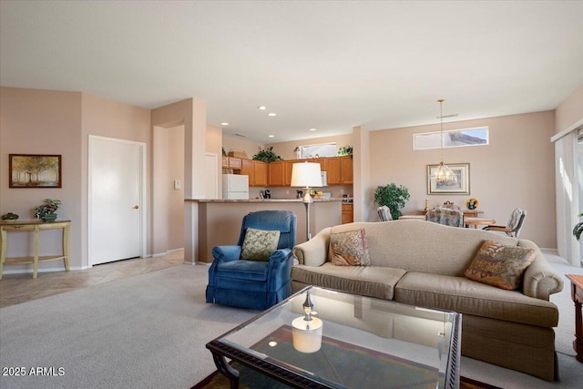 carpeted living room with a notable chandelier