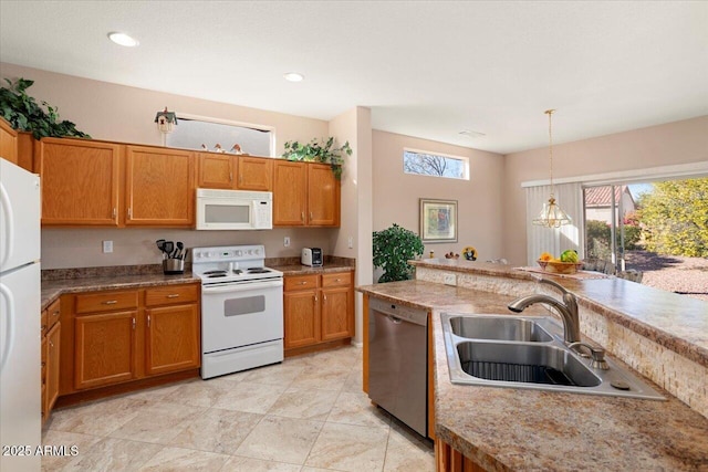 kitchen featuring sink, white appliances, decorative light fixtures, and a chandelier