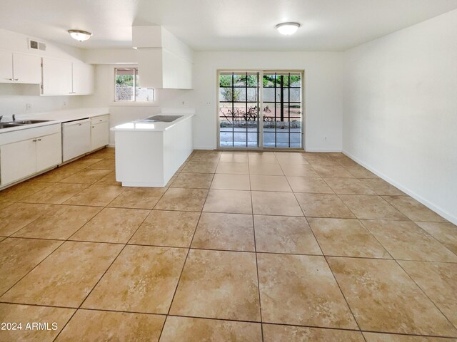 kitchen featuring light tile patterned floors, white cabinetry, white dishwasher, and sink