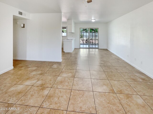 tiled spare room with ceiling fan