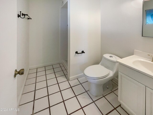 bathroom featuring tile patterned flooring, toilet, and vanity