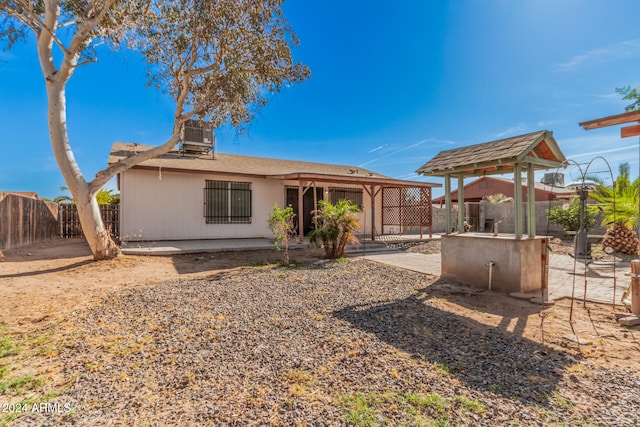 back of property with cooling unit, a patio area, and exterior kitchen