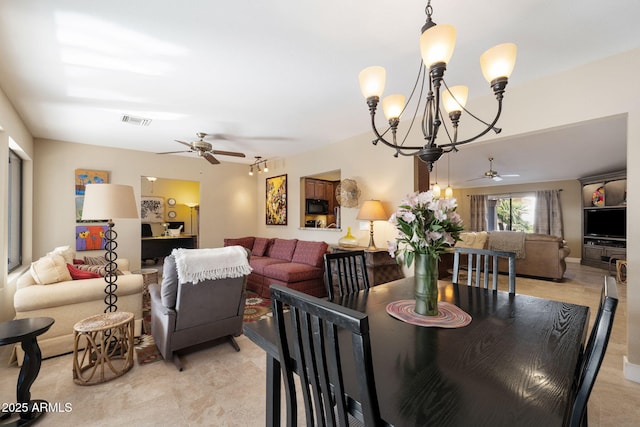 dining space featuring ceiling fan with notable chandelier