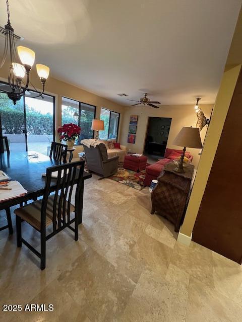 living room featuring ceiling fan with notable chandelier