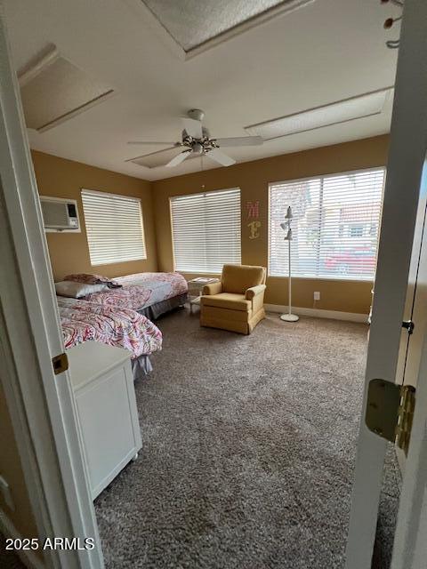 carpeted bedroom with ceiling fan and a wall mounted AC