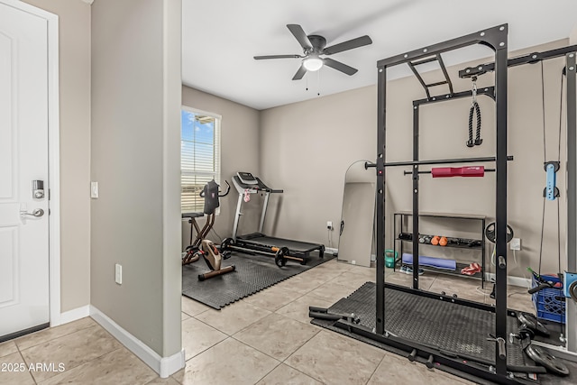workout area with a ceiling fan, baseboards, and tile patterned flooring