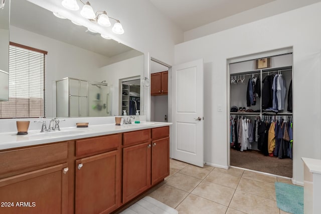 bathroom with tile patterned floors, vanity, and walk in shower