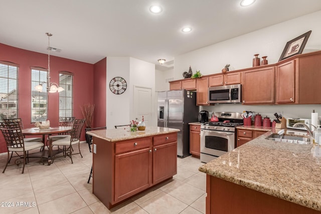 kitchen featuring sink, a kitchen island, decorative light fixtures, light tile patterned flooring, and appliances with stainless steel finishes