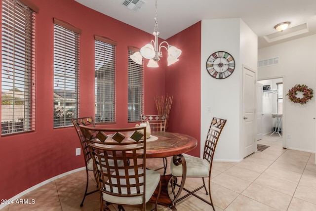 tiled dining space featuring an inviting chandelier