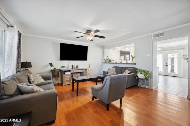 living room featuring ceiling fan, french doors, crown molding, and hardwood / wood-style flooring