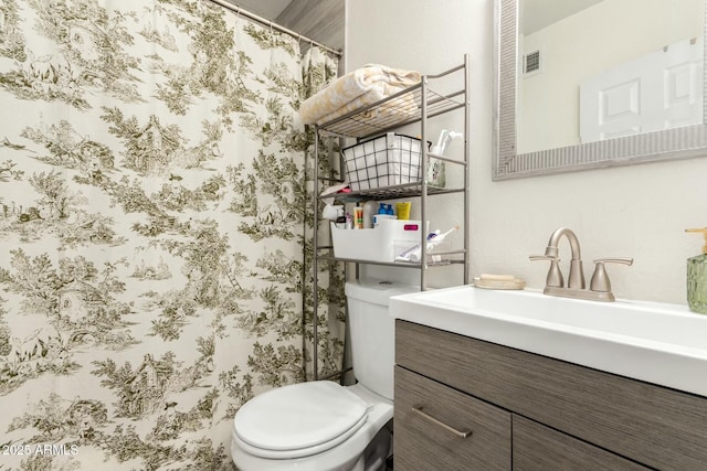 bathroom with curtained shower, toilet, and vanity