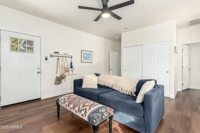 living room featuring ceiling fan and dark wood-type flooring