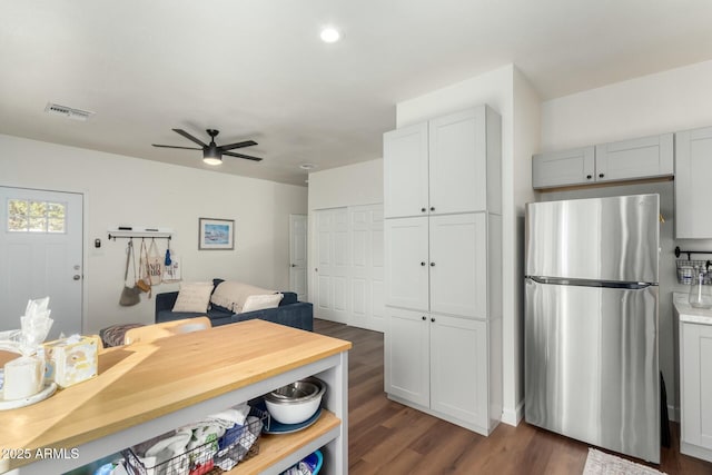 kitchen featuring ceiling fan, dark hardwood / wood-style floors, and stainless steel refrigerator