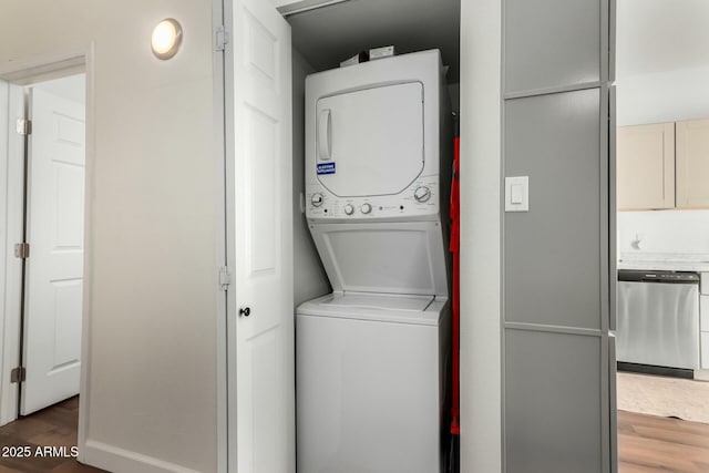 washroom with dark hardwood / wood-style flooring and stacked washer and dryer