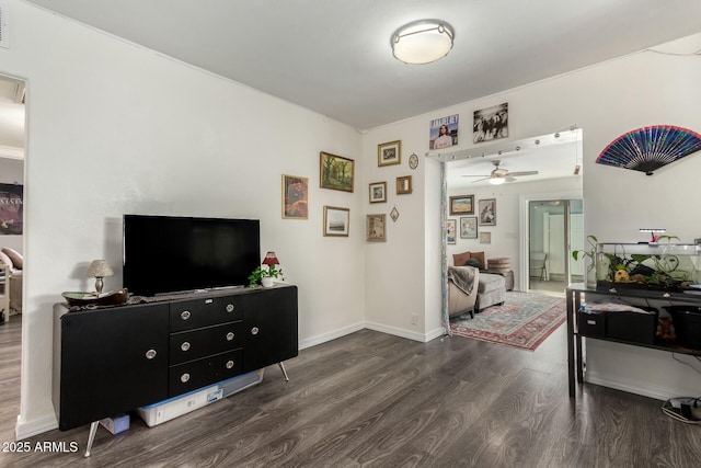 living room featuring ceiling fan and dark wood-type flooring