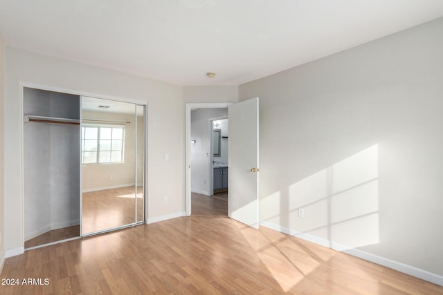 unfurnished bedroom featuring hardwood / wood-style flooring and a closet