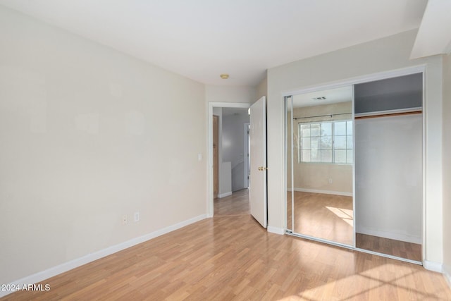 unfurnished bedroom featuring light hardwood / wood-style floors and a closet